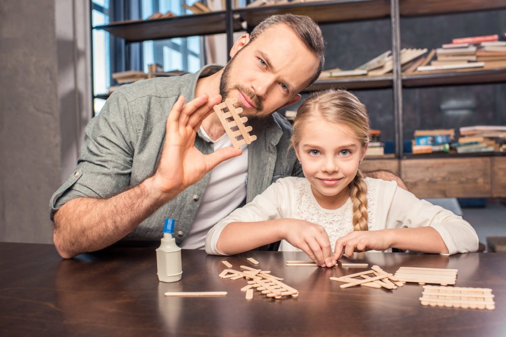 Father and daughter making ice cream wooden sticks figure