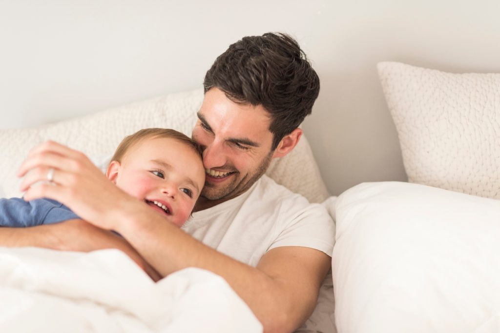 Father and young son laughing together, indoors