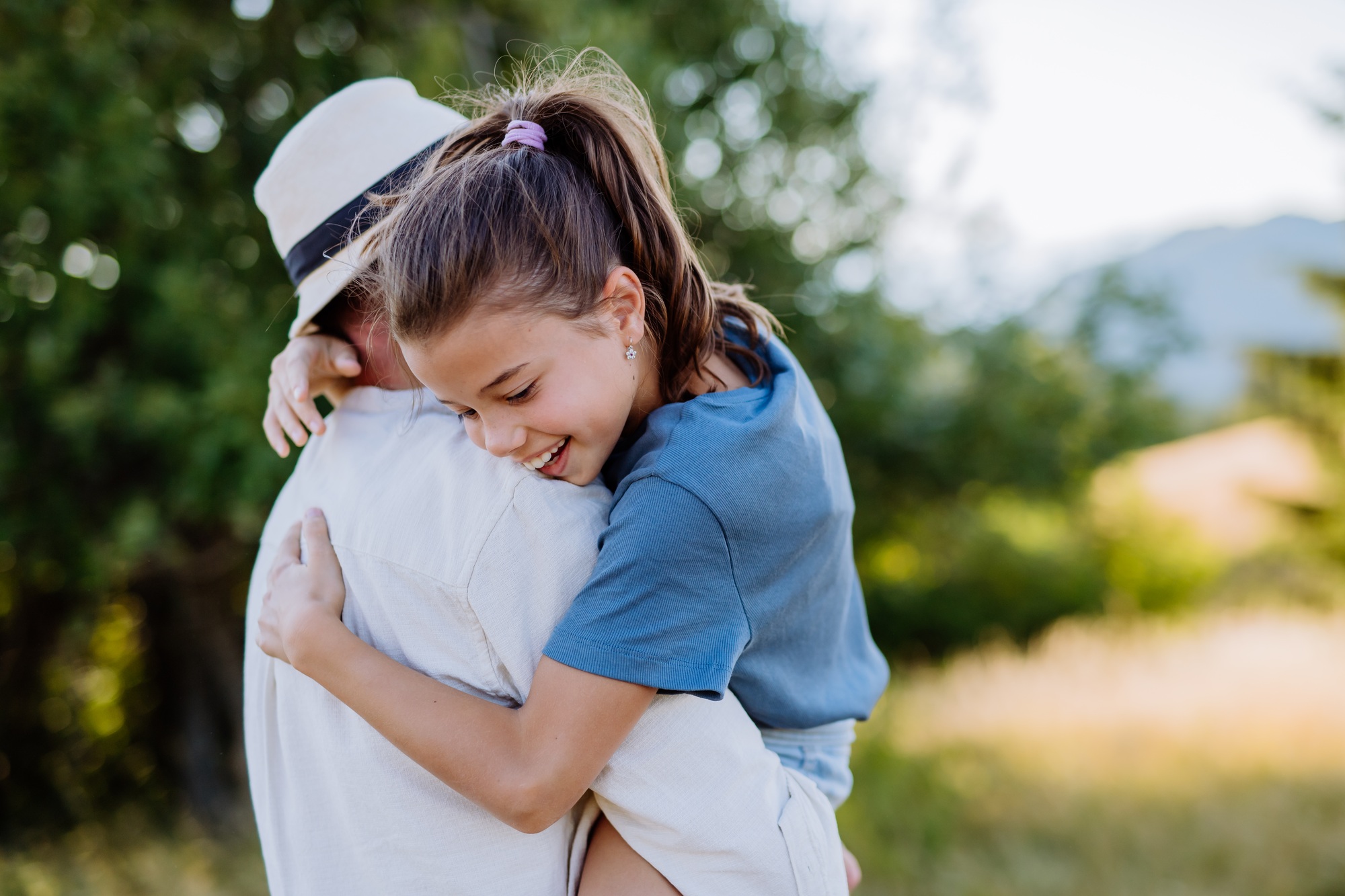 Father hugging his daughter in summer in nature. Father's day concept.