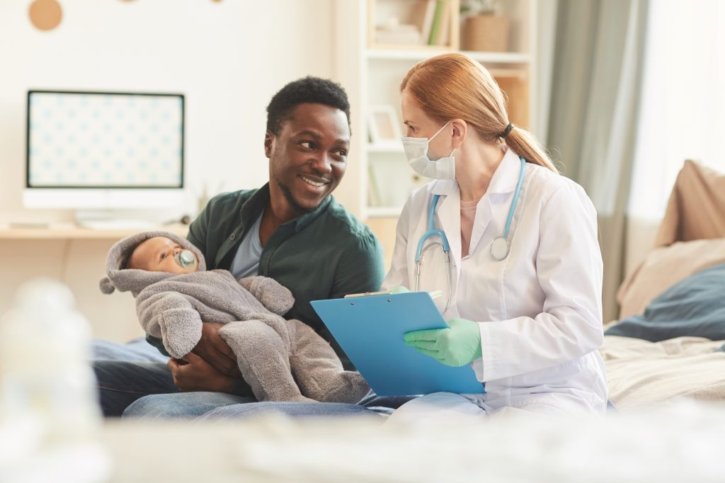 Female Doctor Talking to Smiling Father