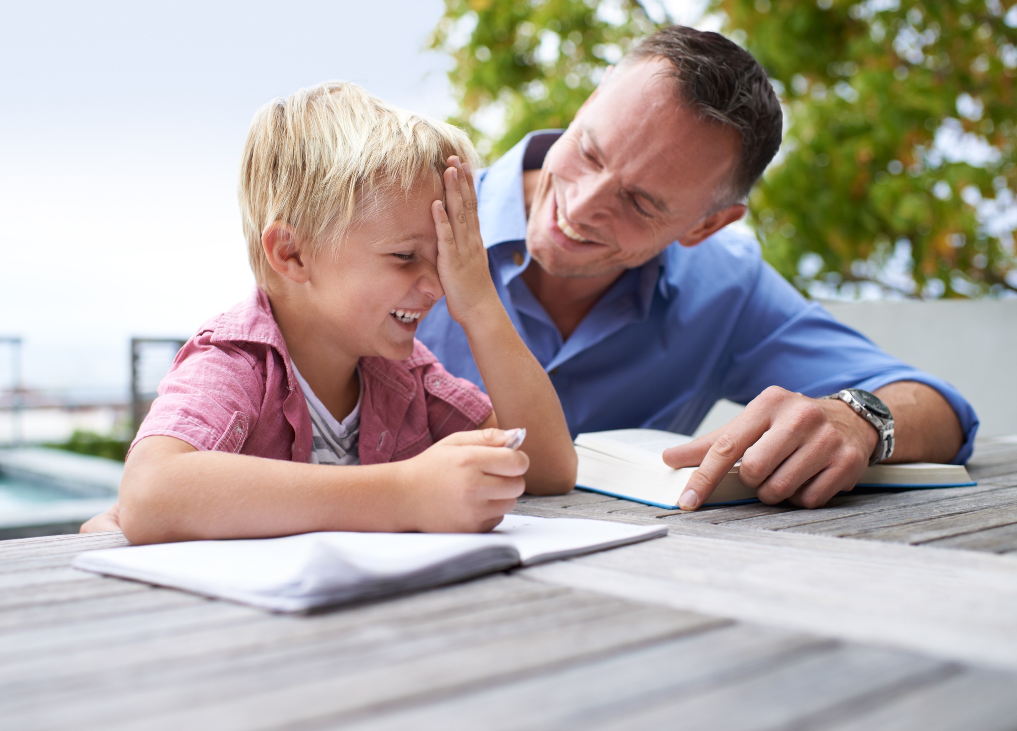 Sharing a joke with dad. Shot of a father helping his son with his coloring book.