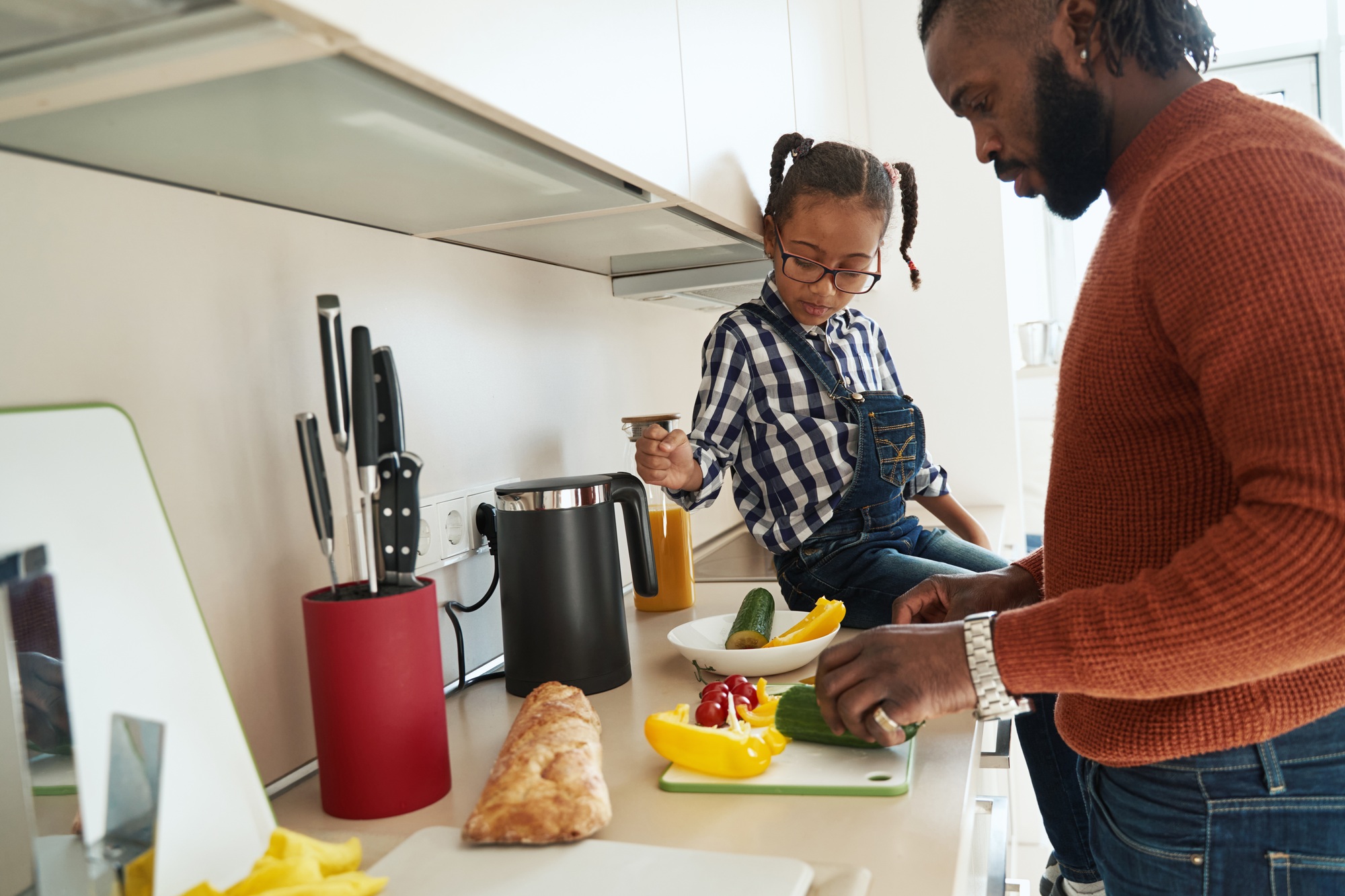 Thoughtful little girl helping her father in the kitchen